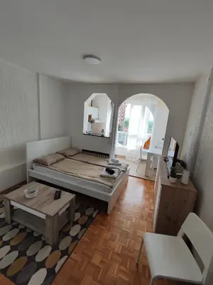 a bedroom with a bed and a table and a mirror at Venac in Belgrade