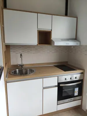 a small kitchen with white cabinets and a sink at Venac in Belgrade