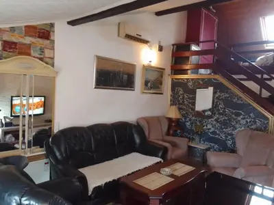 a living room with a leather couch and a table at Apartment Antik Belgrade in Belgrade