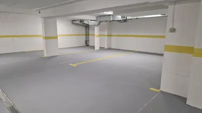 an empty parking garage with white walls and yellow stripes at Apartment Relax 1 in Belgrade