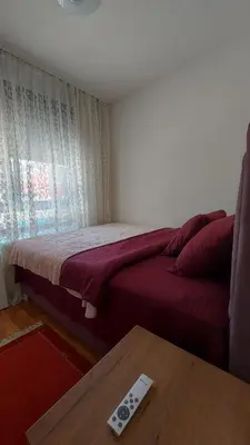 a bedroom with a bed and a remote control on a table at Apartment Relax 1 in Belgrade
