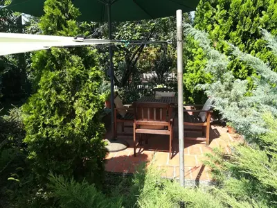 a patio with a table and chairs under an umbrella at Gray apartment in Čukarica