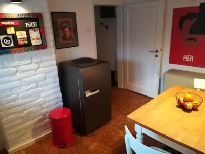 a refrigerator in the corner of a room with a table at Gray apartment in Čukarica