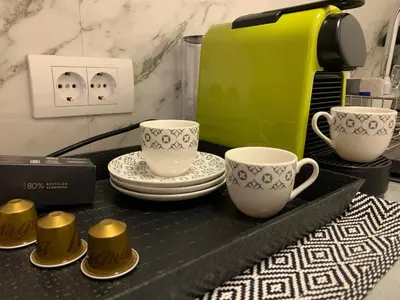 a counter with two cups and plates and a coffee maker at DM apartman Beograd in Vračar (historical)