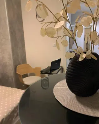 a black vase on a table with a hat on it at DM apartman Beograd in Vračar (historical)