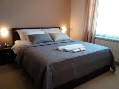 a bedroom with a large bed with two towels on it at Vila Vidikovac Arandjelovac in Arandjelovac