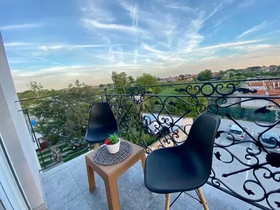 two chairs and a table on a balcony at BellaVista apartman in Stara Pazova