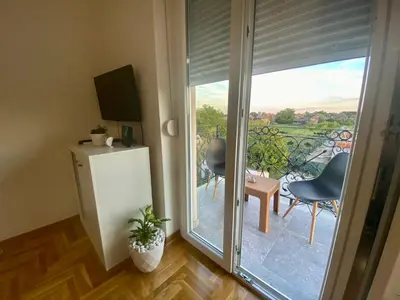 a room with a sliding glass door leading to a balcony at BellaVista apartman in Stara Pazova