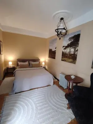a bedroom with a large white bed and a chandelier at Oaza 26 deo 2 in Belgrade