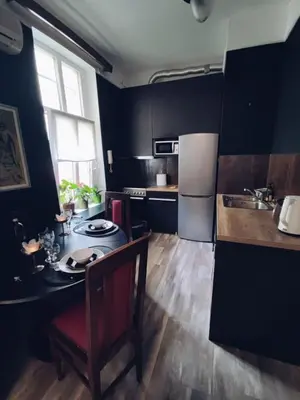 a small kitchen with a table and a refrigerator at Oaza 26 deo 2 in Belgrade