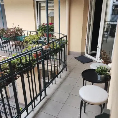 a balcony with two tables and chairs and potted plants at Oaza 26 deo 2 in Belgrade