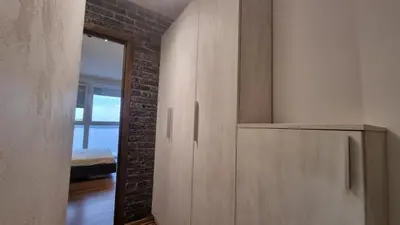 a bedroom with wooden cabinets and a brick wall at Apartments near city center in Belgrade