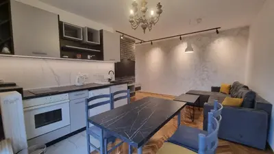 a kitchen and living room with a table and a couch at Apartments near city center in Belgrade