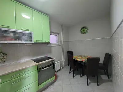 a kitchen with green cabinets and a table with chairs at Xenia apartments in Belgrade