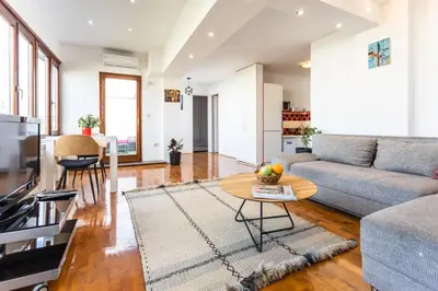 a living room with a couch and a table at Spacious Loft with one bedroom and a big terrace in Belgrade
