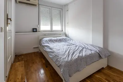 a small bedroom with a bed and a window at Spacious Loft with one bedroom and a big terrace in Belgrade