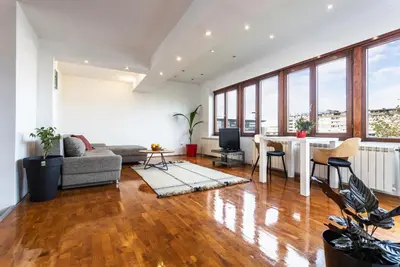 a living room with a couch and a table at Spacious Loft with one bedroom and a big terrace in Belgrade