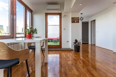 a living room with a white table and chairs at Spacious Loft with one bedroom and a big terrace in Belgrade