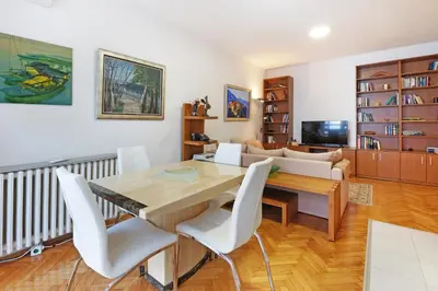 a living room with a wooden table and white chairs at Apartment Paradise Exotic Star in Belgrade