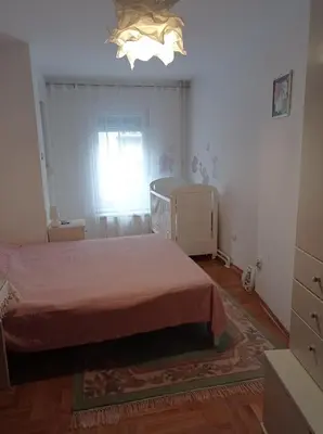 a bedroom with a bed and a chandelier at GO 2 Apartment in Belgrade