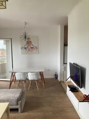 a white living room with a table and a tv at Forest View in Belgrade