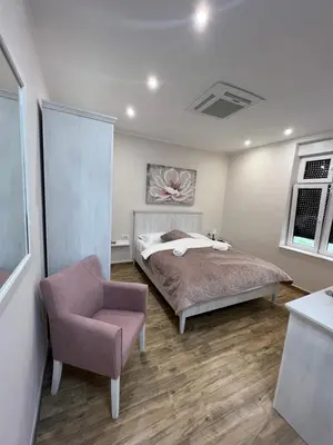 a bedroom with a bed and a chair at Stefy Lux Apartments in Belgrade