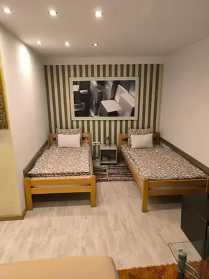 a room with two beds and a painting on the wall at Agape Downtown in Belgrade