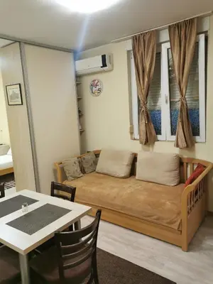 a room with a bed and a table with chairs at Agape Downtown in Belgrade