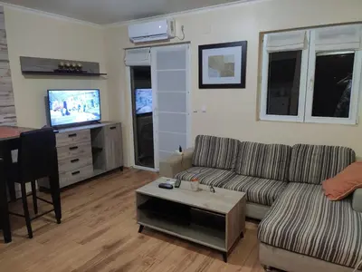 a living room with a couch and a table and a tv at Vidikovac 4 in Belgrade