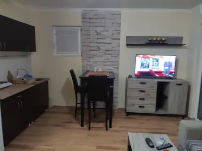 a kitchen with a table and chairs and a television at Vidikovac 4 in Belgrade