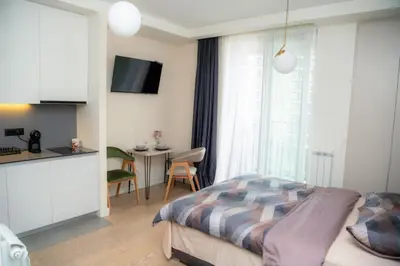 a bedroom with a bed and a kitchen with a table at Belgrade Waterfront Metropolitan 2 in Belgrade