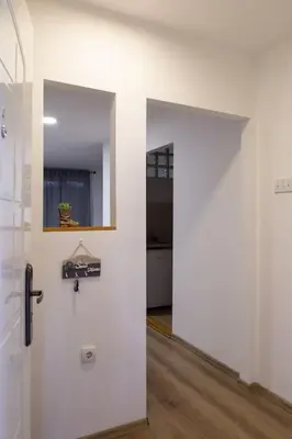 a room with a white wall and a door at Apartman Nelly - Fontana in Fontana
