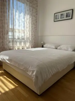a bedroom with a large white bed with a window at Nevena Belville Apartments in Belgrade