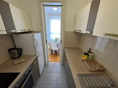 a kitchen with a refrigerator and a table in the background at Nevena Belville Apartments in Belgrade