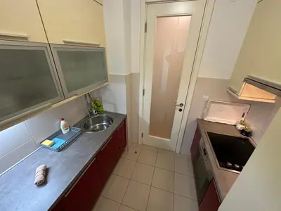 a small kitchen with a sink and a door at Nevena Belville Apartments in Belgrade
