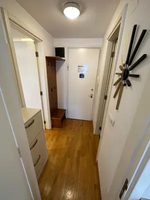 a hallway leading to a room with a door and wooden floors at Nevena Belville Apartments in Belgrade