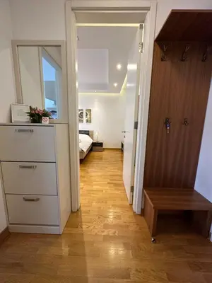 a hallway with a room with a bed and a wooden floor at Nevena Belville Apartments in Belgrade