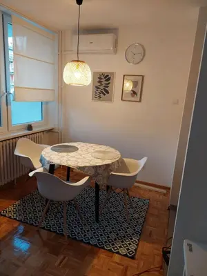 a dining room with a table and chairs and a clock at Dolce vita 1 in Belgrade