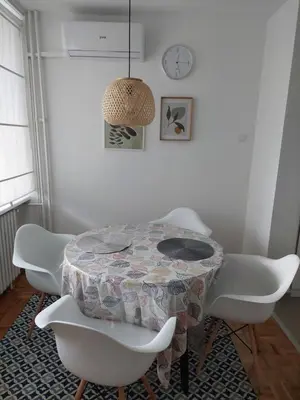 a dining room with a table and white chairs at Dolce vita 1 in Belgrade