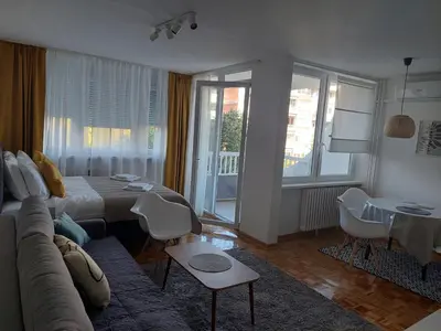 a living room with a couch and a table and chairs at Dolce vita 1 in Belgrade