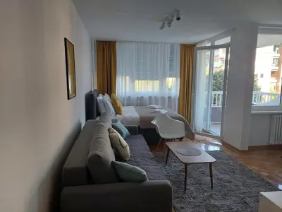 a living room with a couch and a bed and a table at Dolce vita 1 in Belgrade