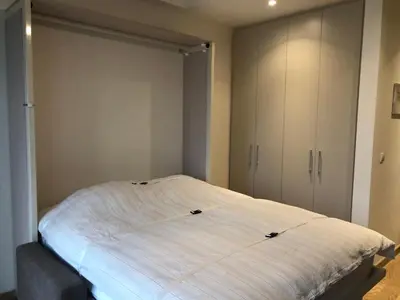 a bedroom with a large white bed in it at Cozy Belgrade Waterfront studio with Murphy bed in Belgrade