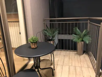 a balcony with a table and potted plants on it at Cozy Belgrade Waterfront studio with Murphy bed in Belgrade