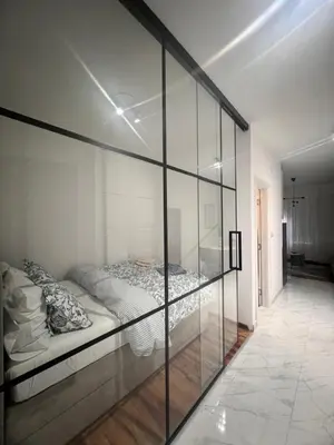 a bedroom with a bed inside of a glass wall at K2 Apartmani in Belgrade