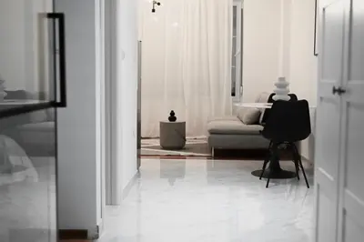 a white living room with a couch and a chair at K2 Apartmani in Belgrade