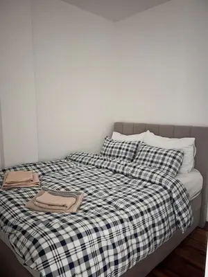 a bed with a black and white checkered blanket at K2 Apartmani in Belgrade