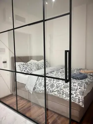 a reflection of a bed in a glass case at K2 Apartmani in Belgrade