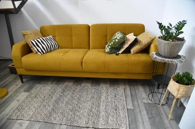 a yellow couch in a living room with pillows on it at Vila Kraljev Breg Fruška Gora Pool and Padel in Čortanovci