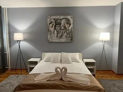 a bedroom with a bed with two lamps and a painting on the wall at Iskra Apartment in Belgrade
