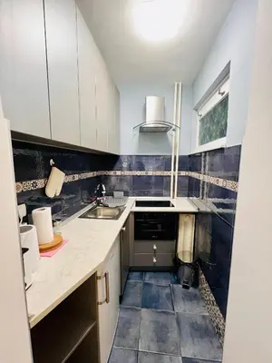 a kitchen with white cabinets and a sink at Iskra Apartment in Belgrade